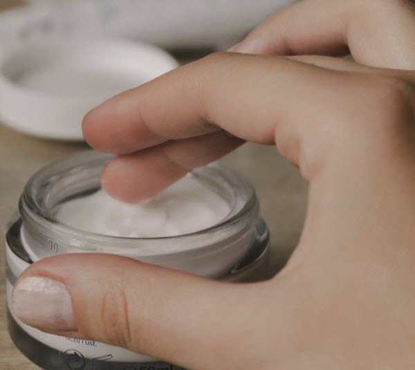 fingers scooping moisturizing cream
